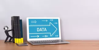 Könyvek, mellette egy laptop, data felirattal egy nyílon.